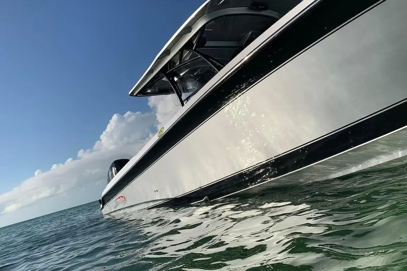 Slide: The Image of 2017 Nor-Tech 340 Sport Center Console boat on open water under clear sky. - 4