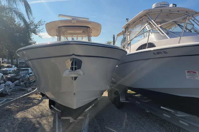 Slide: The Image of 2019 Grady-White Canyon 306 boat on trailer, parked beside another boat. - 1