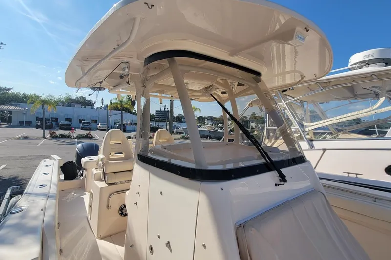 Slide: The Image of 2019 Grady-White Canyon 306 boat with seating and canopy in a marina setting. - 17