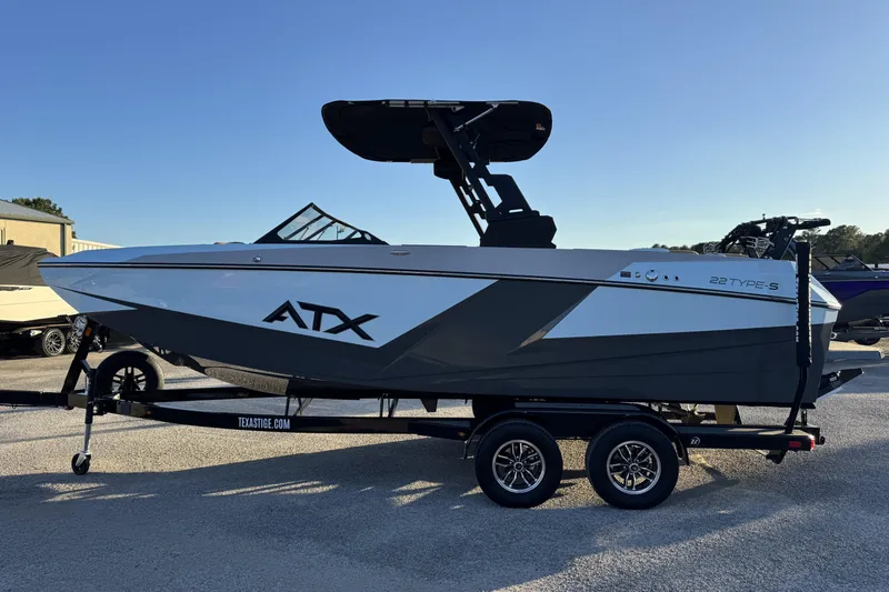 Slide: The Image of 2026 ATX Surf Boats 22 Type-S on trailer, sleek design under clear sky. - 4