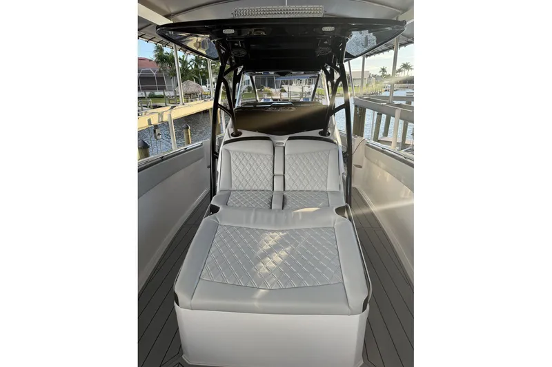 Slide: The Image of 2025 Nor-Tech 390 Sport Center Console with luxurious seating, docked by the water. - 18