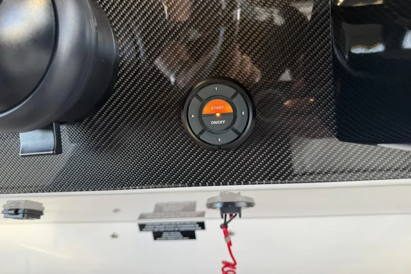 Slide: The Image of 2025 Nor-Tech 390 Sport Center Console dashboard with carbon fiber finish and start button. - 19