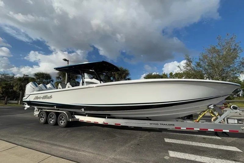 Slide: The Image of 2025 Nor-Tech 390 Sport Center Console boat on trailer under a partly cloudy sky. - 3