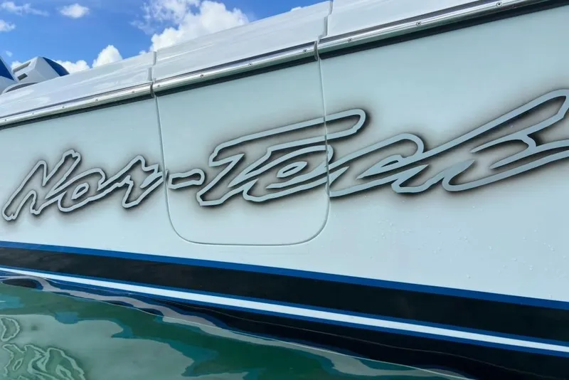 Slide: The Image of 2025 Nor-Tech 390 Sport Center Console boat with sleek logo on the side. - 5
