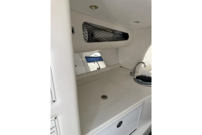 Slide: The Image of Interior of 1999 Hustler 388 SLINGSHOT boat with sink and storage area. - 8