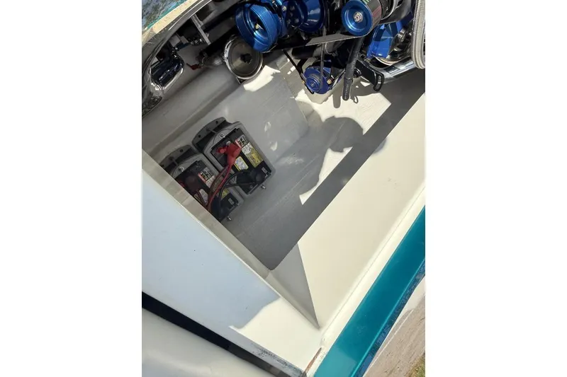 Slide: The Image of 1999 Hustler 388 SLINGSHOT engine compartment with batteries and blue engine components. - 9