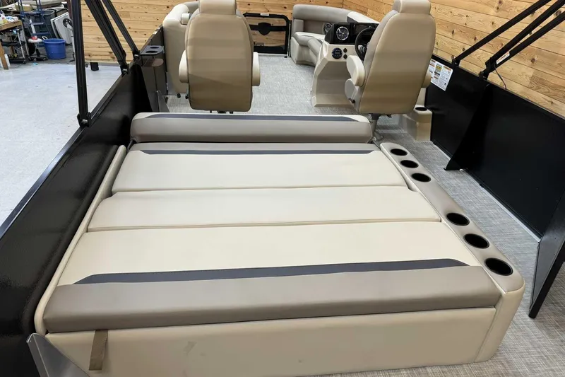Slide: The Image of 2025 Premier Sunscape 220 RL boat interior with beige seating and cup holders. - 10