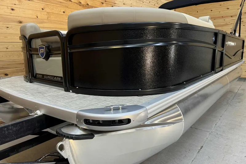 Slide: The Image of 2025 Premier Sunscape 220 RL pontoon boat, sleek black design, wooden background. - 4