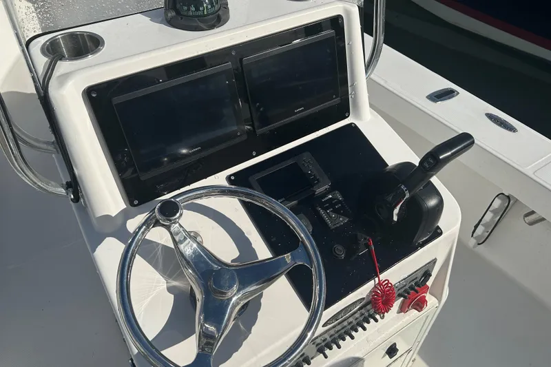 Slide: The Image of Control panel of a 2007 SeaCraft 20 Classic boat with steering wheel and navigation equipment. - 8