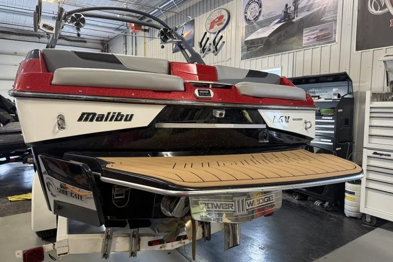 Slide: The Image of 2019 Malibu Wakesetter 23 LSV boat in a garage, showcasing rear deck and branding. - 25