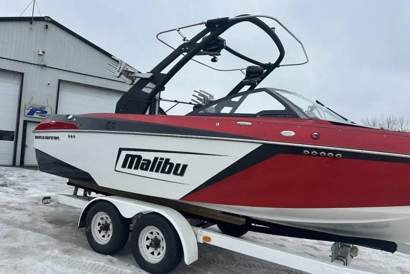 Slide: The Image of 2019 Malibu Wakesetter 23 LSV boat on trailer, red and white design, parked outside. - 5
