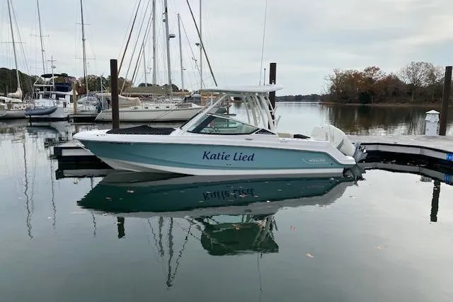 The Image of 2021 Boston Whaler 240 Vantage boat docked in a marina, clear blue sky. - 0