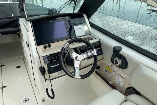 Slide: The Image of 2021 Boston Whaler 240 Vantage boat interior with seating and helm, dockside view. - 2