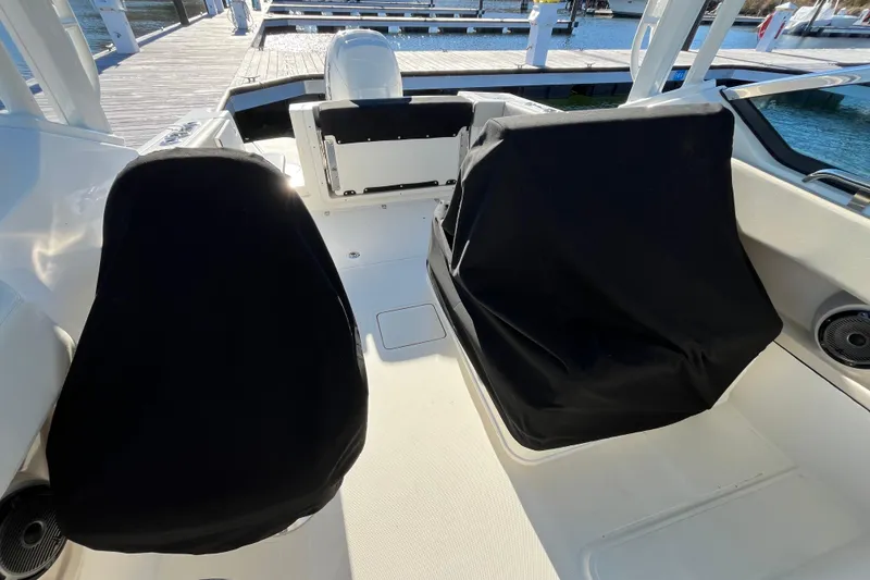 Slide: The Image of 2021 Boston Whaler 240 Vantage boat interior with covered seats at dock. - 28