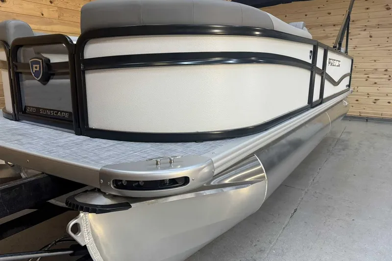 Slide: The Image of 2025 Premier Sunscape 220 RL pontoon boat in a wooden dock setting. - 4