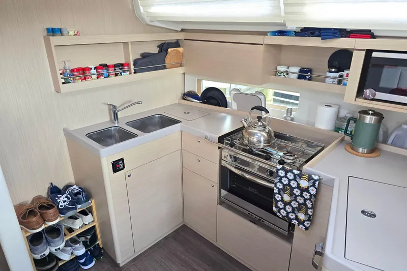 Slide: The Image of Modern kitchen in 2022 Beneteau Oceanis 40.1 yacht with stove, sink, and storage. - 6