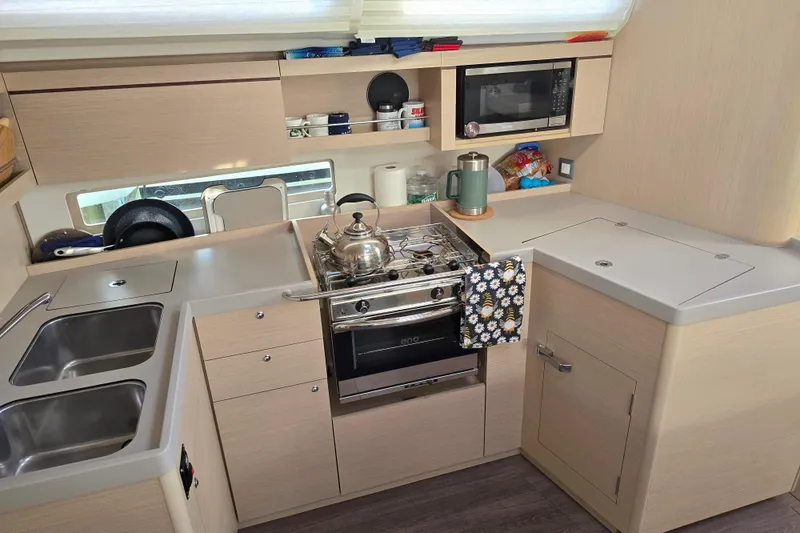 Slide: The Image of Modern kitchen in 2022 Beneteau Oceanis 40.1 yacht with stove, sink, and microwave. - 7