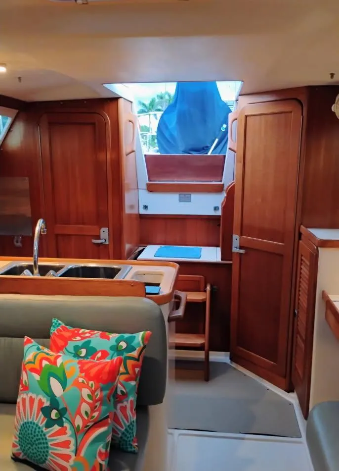 Slide: The Image of Interior of 2002 Catalina 34 Mark II sailboat with wooden cabinetry and colorful cushions. - 10