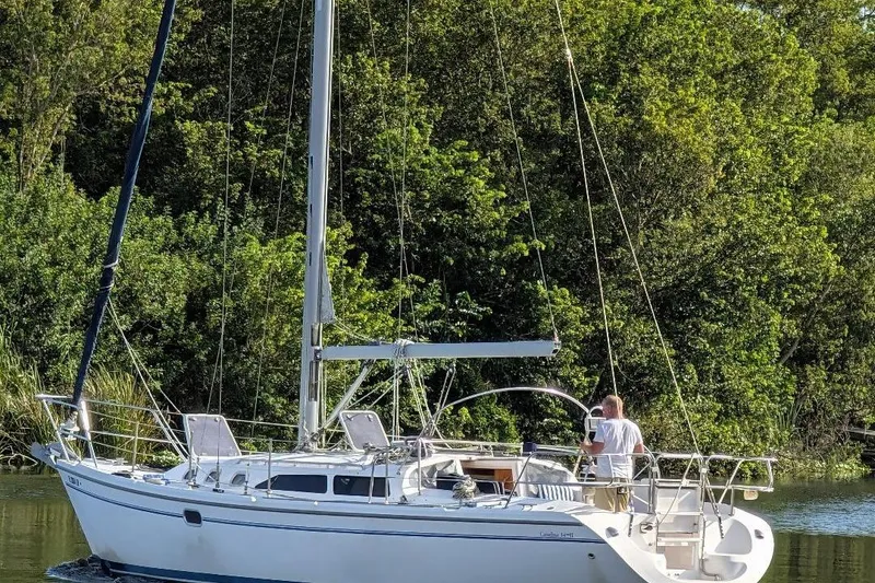 Slide: The Image of 2002 Catalina 34 Mark II sailboat on a serene waterway, surrounded by lush greenery. - 3
