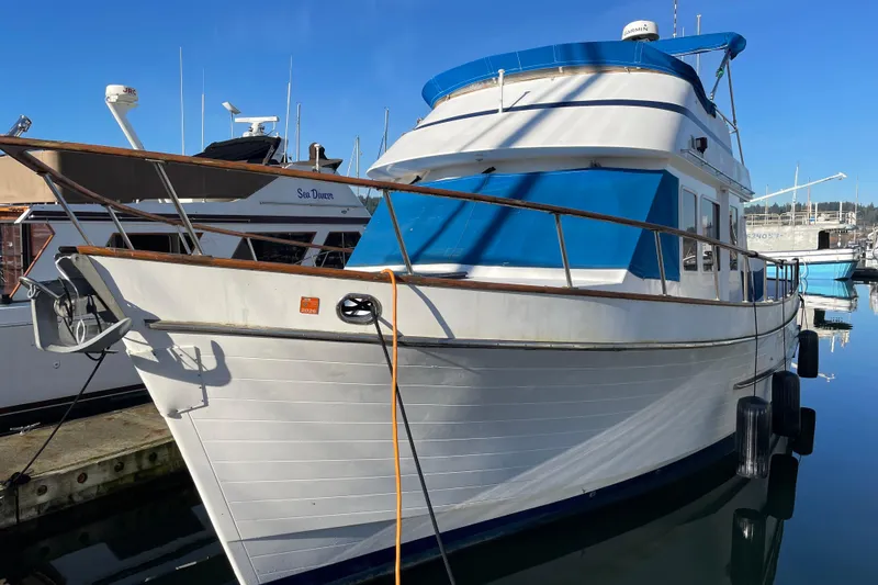 Slide: The Image of 1985 Ocean Alexander 38 Double Cabin yacht docked in marina, featuring blue accents. - 1