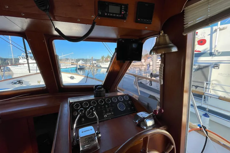 Slide: The Image of 1985 Ocean Alexander 38 Double Cabin helm with classic controls and marina view. - 11