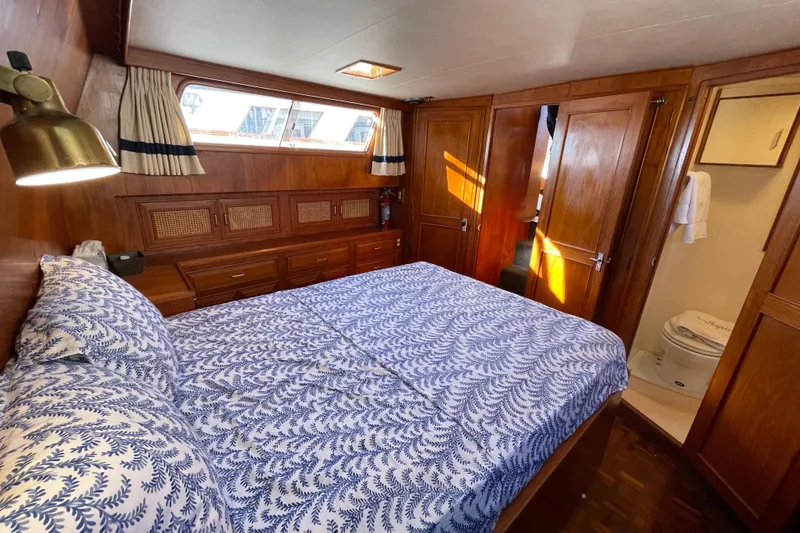 Slide: The Image of 1985 Ocean Alexander 38 Double Cabin bedroom with wood paneling and ensuite bathroom. - 17