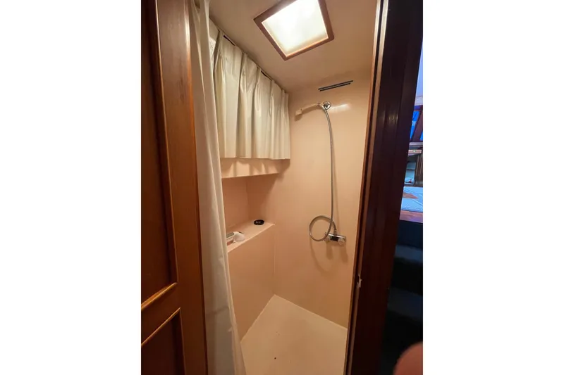 Slide: The Image of Shower area in 1985 Ocean Alexander 38 Double Cabin yacht, featuring curtain and handheld showerhead. - 19