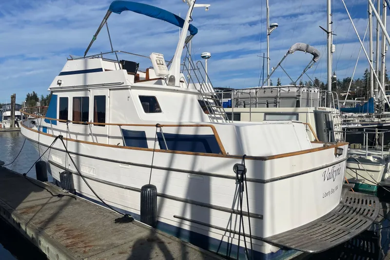 Slide: The Image of 1985 Ocean Alexander 38 Double Cabin yacht docked at marina under blue sky. - 2