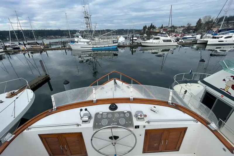 Slide: The Image of 1985 Ocean Alexander 38 Double Cabin yacht docked at a marina, surrounded by boats. - 5