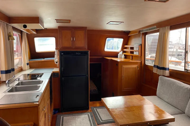Slide: The Image of 1985 Ocean Alexander 38 Double Cabin interior with kitchen, dining area, and wooden cabinetry. - 7