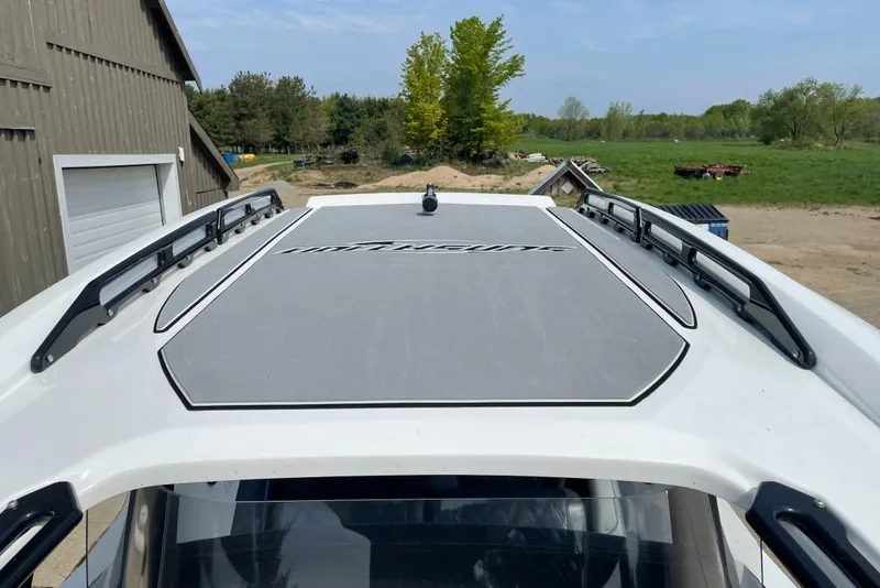 Slide: The Image of 2019 Sunsation 32 CCX boat roof with logo, surrounded by rural landscape. - 4