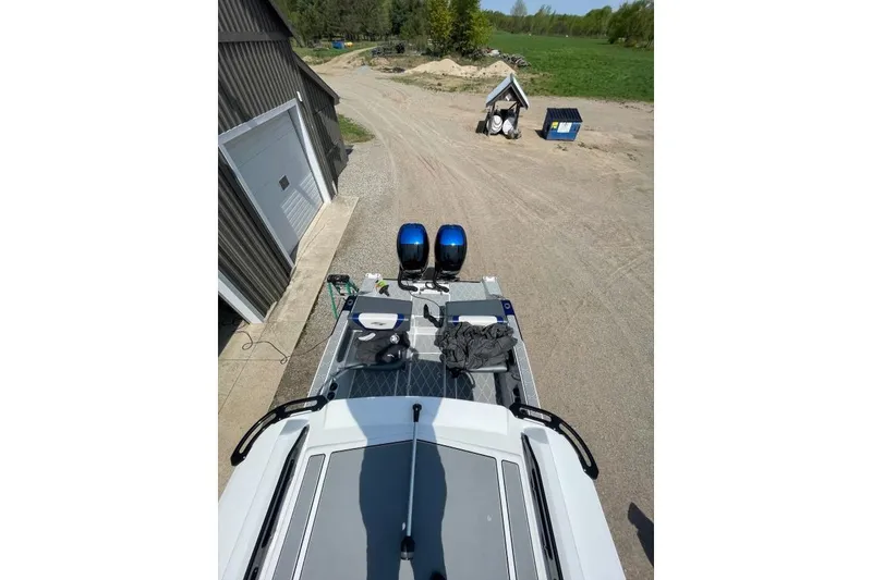 Slide: The Image of 2019 Sunsation 32 CCX boat with dual engines, parked near a garage on a sunny day. - 6