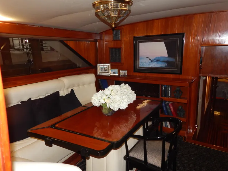 Slide: The Image of 1974 Pacemaker Cockpit Motoryacht interior with elegant wood paneling and cozy dining area. - 11