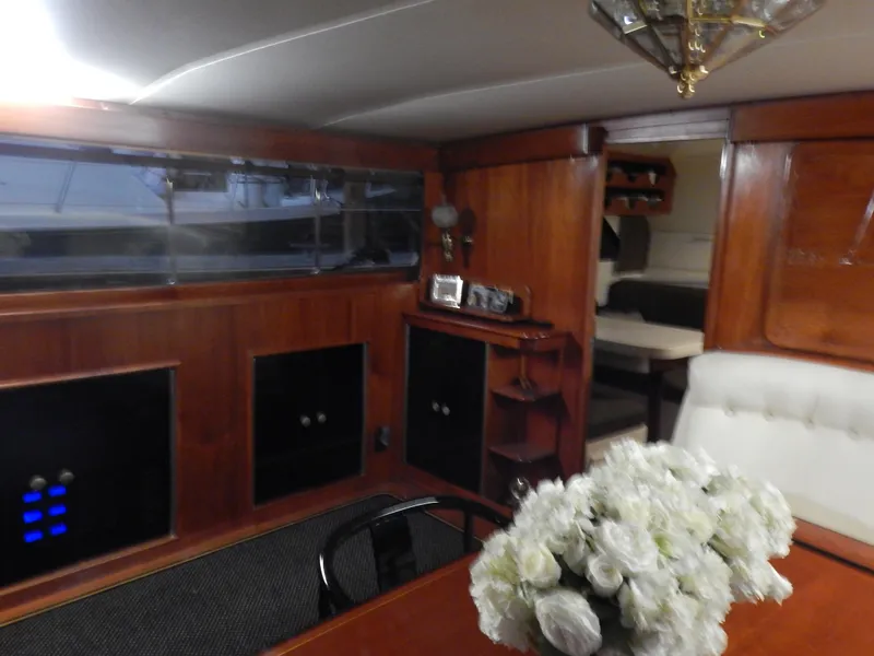 Slide: The Image of 1974 Pacemaker Cockpit Motoryacht interior with wood paneling and floral centerpiece. - 13