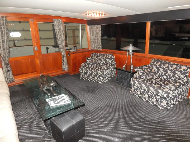 Slide: The Image of Interior of a 1974 Pacemaker Cockpit Motoryacht with floral chairs and wooden accents. - 2