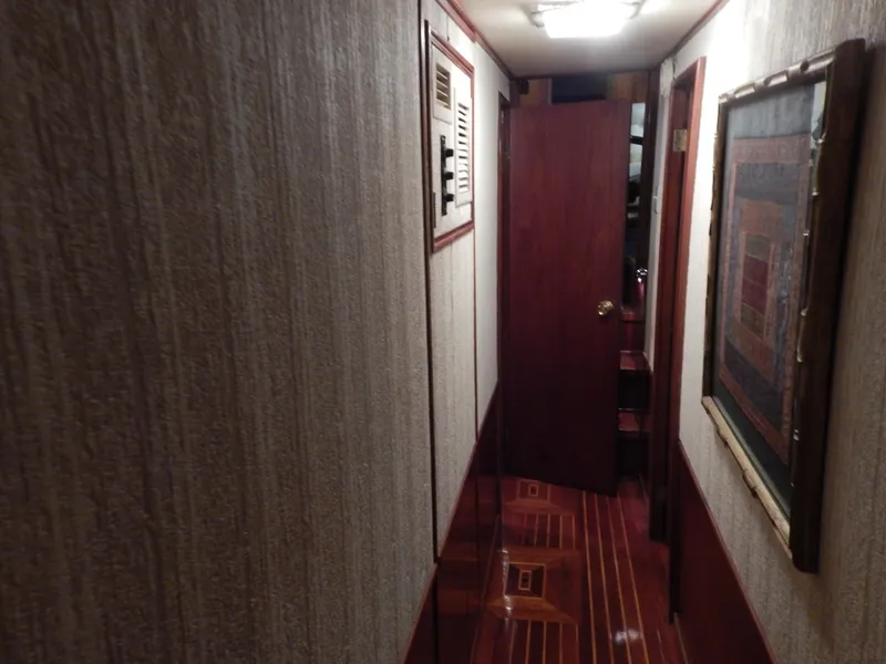 Slide: The Image of 1974 Pacemaker Cockpit Motoryacht interior hallway with wood paneling and framed artwork. - 22