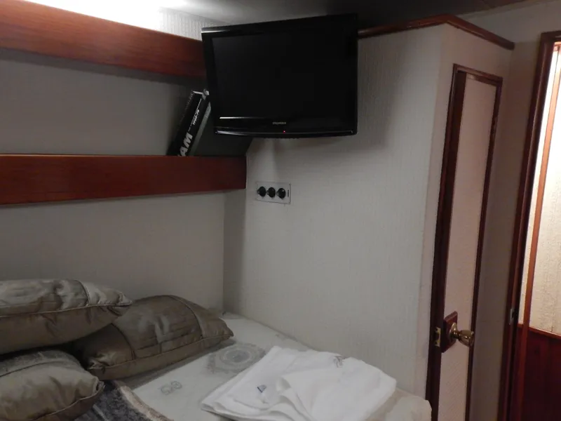 Slide: The Image of 1974 Pacemaker Cockpit Motoryacht cabin with TV, bed, and wooden accents. - 24