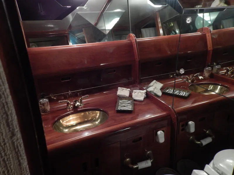 Slide: The Image of Luxurious wooden bathroom vanity on a 1974 Pacemaker Cockpit Motoryacht with brass sink fixtures. - 25