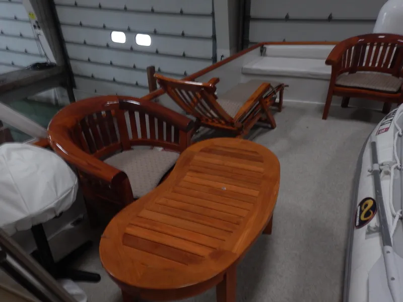 Slide: The Image of 1974 Pacemaker Cockpit Motoryacht with elegant wooden deck furniture in a garage setting. - 29