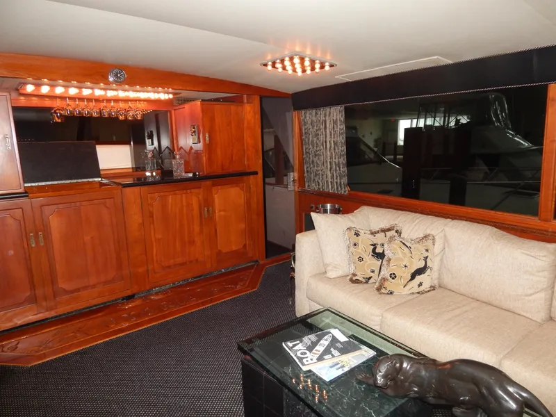 Slide: The Image of 1974 Pacemaker Cockpit Motoryacht interior with wooden cabinetry, beige sofa, and decorative accents. - 3
