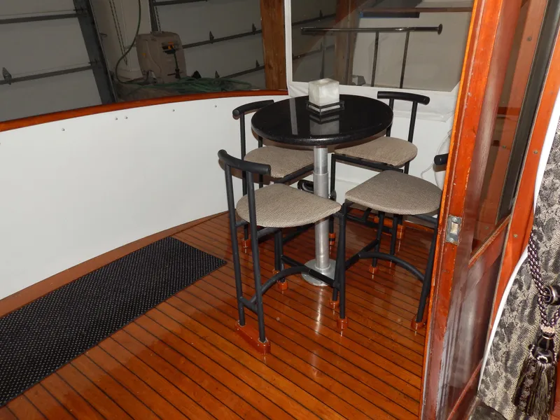 Slide: The Image of 1974 Pacemaker Cockpit Motoryacht interior with wooden flooring and a round table with chairs. - 33