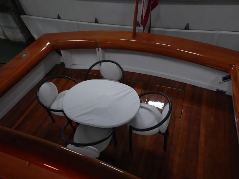 Slide: The Image of 1974 Pacemaker Cockpit Motoryacht with elegant wooden deck and round table seating. - 35