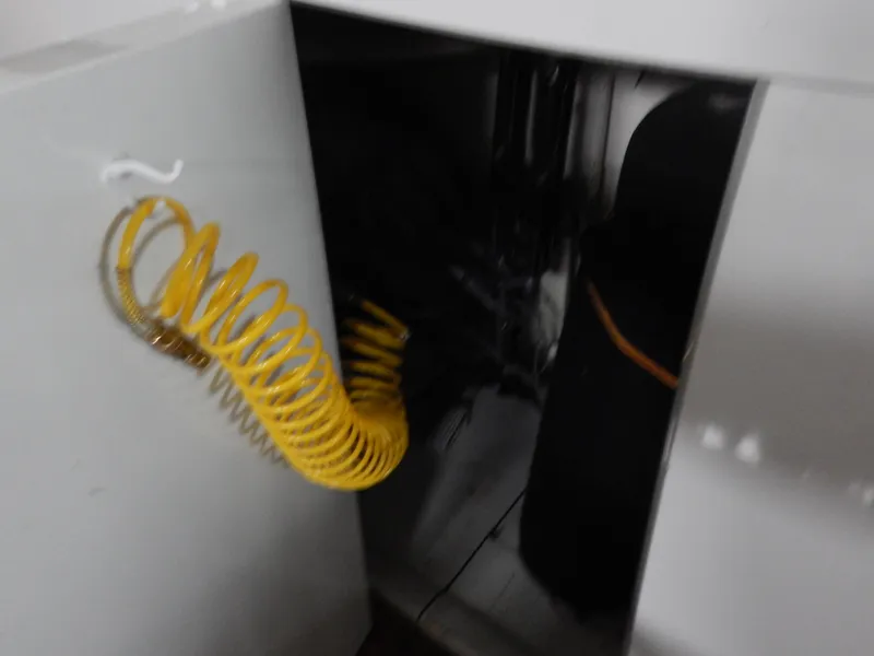 Slide: The Image of 1974 Pacemaker Cockpit Motoryacht interior with yellow coiled hose and storage compartment. - 37