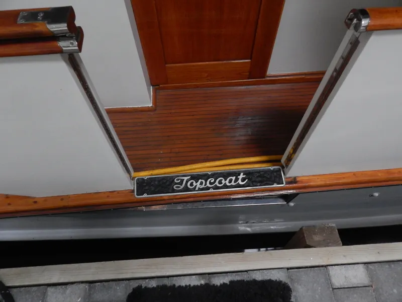 Slide: The Image of Entrance of 1974 Pacemaker Cockpit Motoryacht with "Topcoat" nameplate, wooden deck, and metal railings. - 38