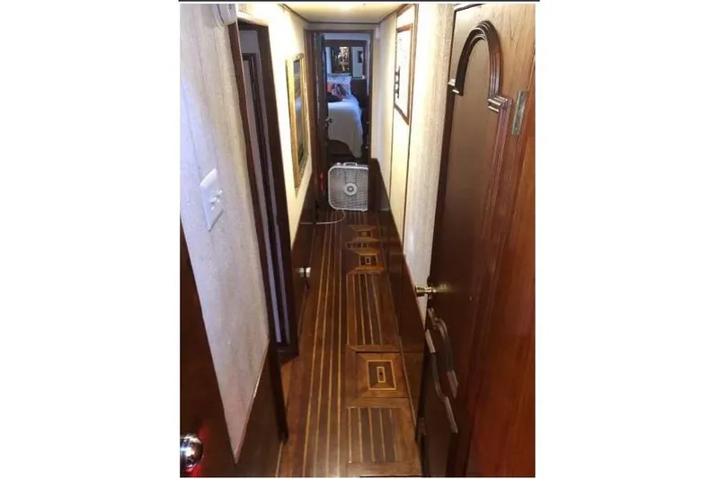 Slide: The Image of Narrow hallway inside a 1974 Pacemaker Cockpit Motoryacht with wooden flooring and doors. - 41