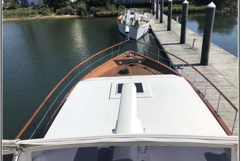Slide: The Image of 1974 Pacemaker Cockpit Motoryacht docked at a marina, viewed from the bow. - 47