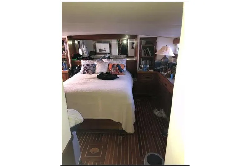 Slide: The Image of 1974 Pacemaker Cockpit Motoryacht bedroom with cozy bed, wooden interior, and decorative pillows. - 49