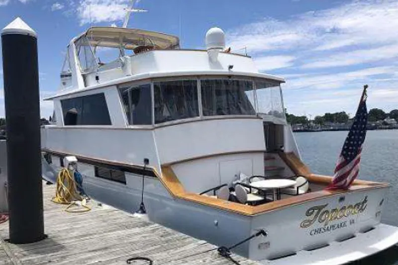 Slide: The Image of 1974 Pacemaker Cockpit Motoryacht docked, featuring American flag and outdoor seating. - 52