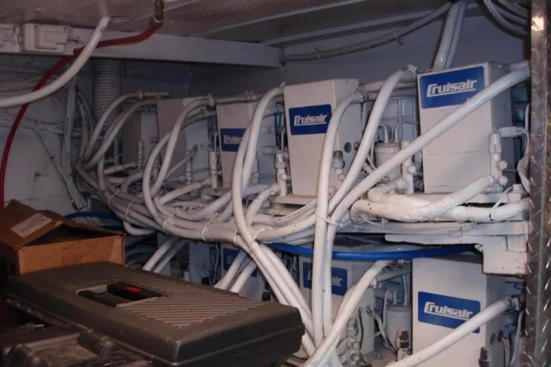 Slide: The Image of Cruisair units in a 1974 Pacemaker Cockpit Motoryacht engine room, surrounded by cables. - 71