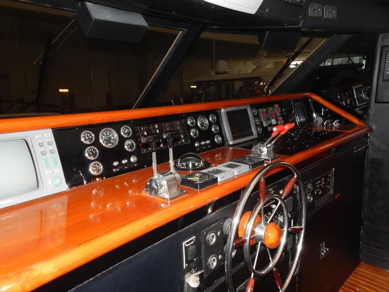 Slide: The Image of 1974 Pacemaker Cockpit Motoryacht helm with wooden dashboard, steering wheel, and navigation instruments. - 8